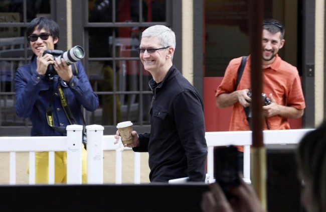 Tim Cook, Apple CEO smiles as he looks at a news conference being held by Eric Schmidt, executive chairman of Google at the annual Allen and Co. conference in Sun Valley