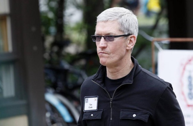 Tim Cook, Apple CEO walks past a news conference being held by Eric Schmidt, executive chairman of Google at the annual Allen and Co. conference in Sun Valley